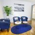 Basement Rotherbaum, Hamburg: lounge with blue chairs, white tables, bookshelf and potted plants