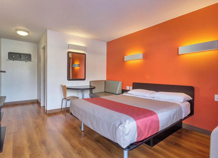 Motel 6 Santa Rosa - South guest room with bed, orange accent wall, and sitting area in Santa Rosa
