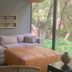 Rodavento Valle de Bravo lounge with sofa, ottoman and forest-view floor-to-ceiling window