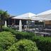 Novotel Bordeaux Lac outdoor terrace with umbrellas, tables, and lush garden landscaping in Bordeaux