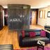 Glenskirlie Castle Hotel in Glasgow lounge with black leather sofas, floral wallpaper and sheer canopy bed