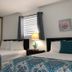 The Beach Guesthouse in La Torre guest room with two beds, mirrored closet, and bedside lamps