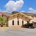 Super 8 by Wyndham Keokuk exterior with parking lot, U.S. flag, and blue sky