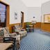 Super 8 by Wyndham Keokuk lobby seating area with patterned chairs and front desk window