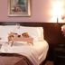 Hotel City Piacenza guest room with double bed, breakfast tray, bedside lamps and floral decor