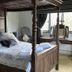 The Leather Bottle in Gravesend: four-poster bed in a wood-paneled guest room with window seat