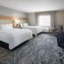 Candlewood Suites Williamsport guest room with two beds, desk, chair and window seating