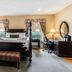 Traditions Hotel & Spa Johnson City guest room with four-poster bed, seating area and desk