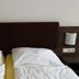 Hotel Vinothek Schwarzer Adler room with two single beds and dark wood headboard in Ottensheim