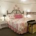 The Garden Walk Bed & Breakfast in Lookout Mountain guest room with floral bed, bedside lamps and window