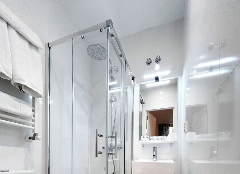 Pensión Régil San Sebastian bathroom with glass shower, sink, toilet and wood-look floor