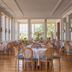 Grand Hotel Europa Palace in Sorrento dining room with round tables, wicker chairs and large windows