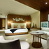 TRS Coral Hotel - Adults Only in Cancún guest room with king bed, sofa, and wood-paneled walls