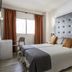 Bedroom at Apartamentos Oasis Sa Tanca in Santa Eulària des Riu with twin beds, large tufted headboard and window seating