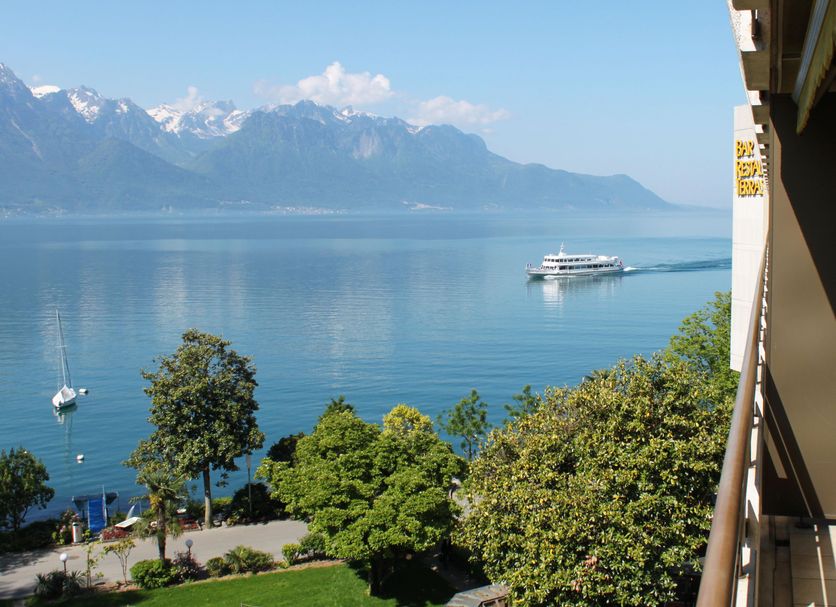 Royal Plaza Montreux in Montreux with lake view, mountains, and a boat on the water