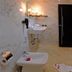 Appart Hotel Mouna Marrakech bathroom with marble walls, bidet, sink, and open black door