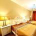 Motel Casa Penn in Newark guest room with two beds, bedside lamps, wall-mounted TV and red curtains
