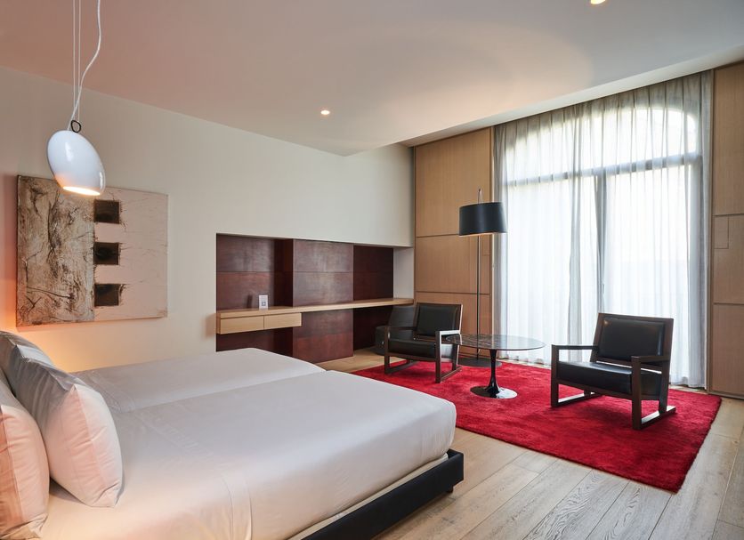 Mercer Casa Torner i Güell in Vilafranca del Penedès: modern hotel room with red rug and floor-to-ceiling window