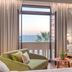 Electra Palace Thessaloniki room with sea view, open balcony doors, and green lounge chairs in Thessaloniki.