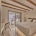 Balius Mykonos bedroom with vaulted ceiling, terrace doors, and sea view in Mykonos