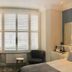 A Room With A View, Brighton: guest room with bed, desk, armchair and shuttered window