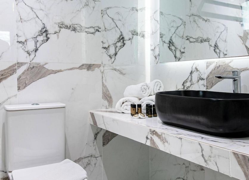 Bomo Assa Maris Beach bathroom in Pyrgadikia with marble-look tile, black vessel sink and toilet