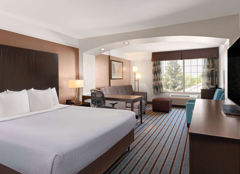 La Quinta Inn & Suites by Wyndham Bakersfield North guest room with king bed, desk, and window seating in Bakersfield