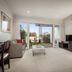 Quest Sanctuary Lakes in Melbourne living area with sliding doors to a patio and garden view