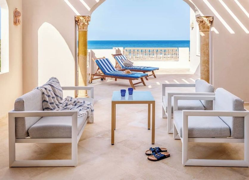 Tui Blue Palm Beach Palace in Midoun lounge with sofas opening to a sea-view terrace and sun loungers