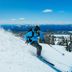 Mossbrae Hotel in Dunsmuir, skier carving down a snowy mountain slope with blue sky and distant peaks