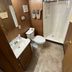Denali RV Park and Motel in Healy bathroom with shower, toilet, sink and wood-paneled walls