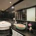 Ja Cosmo Hotel and Spa Hanoi bathroom with a white jacuzzi tub and black tiled walls