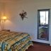 Scottish Inns Mcminnville guest room with king bed, bedside lamps, and wall mirror in McMinnville