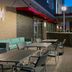 Hampton Inn & Suites Atlanta Buckhead Place patio with tables, chairs, and outdoor fireplace in Atlanta