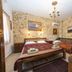 Spot Hotel Rhodes room with stone walls, two beds, chandelier and wooden furnishings