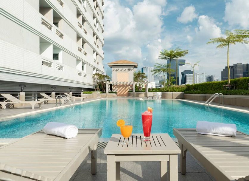 Bu Place Hotel Bangkok poolside loungers with drinks beside an outdoor swimming pool