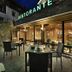 Outdoor terrace at Hotel Valtellina in Livigno with tables beside a glass-front restaurant.