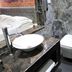 Sri Nanak Continental Hotel New Delhi bathroom with vessel sink, wall-mounted toilet and marble finish
