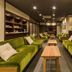 Ryokan Ryokufuso Kyoto lounge with green sofas, wooden tables, and recessed ceiling lights