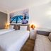 Novotel Dijon Sud in Marsannay-la-Côte guest room with two twin beds and cityscape wall art