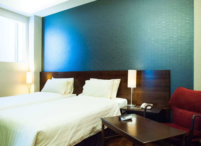 Baan Silom Soi 3 in Bangkok hotel room with two beds, bedside lamps, and a seating area