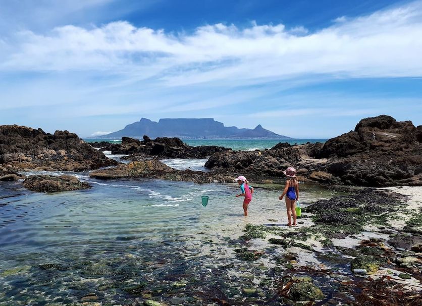 Dolphin Inn Blouberg in Cape Town with rocky tide pools and Table Mountain in the distance