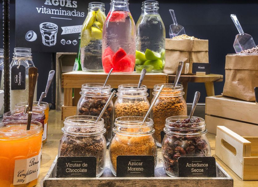 Breakfast buffet at ibis Barcelona Santa Coloma with jars of toppings and fresh fruit-infused water