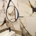 Pousada Gente Bonita La Mansion bathroom with marble-look walls, round mirror, and sink in Búzios
