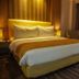 Orchardz Hotel Industri Jakarta room with king bed, warm lighting, and city view through curtains
