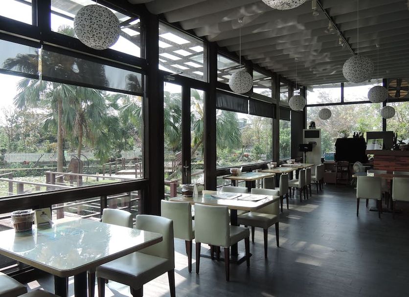 The House of Water in Dongshan Township dining area with floor-to-ceiling windows and garden views