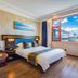 Lijiang International Hotel room with king bed and large window overlooking Lijiang rooftops