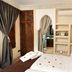 Riad Belle Epoque Marrakech guest room with bed, carved wood screen, arched opening, and air conditioner