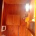 Wood House Pattaya room with warm wood-paneled walls and ceiling lights in Pattaya