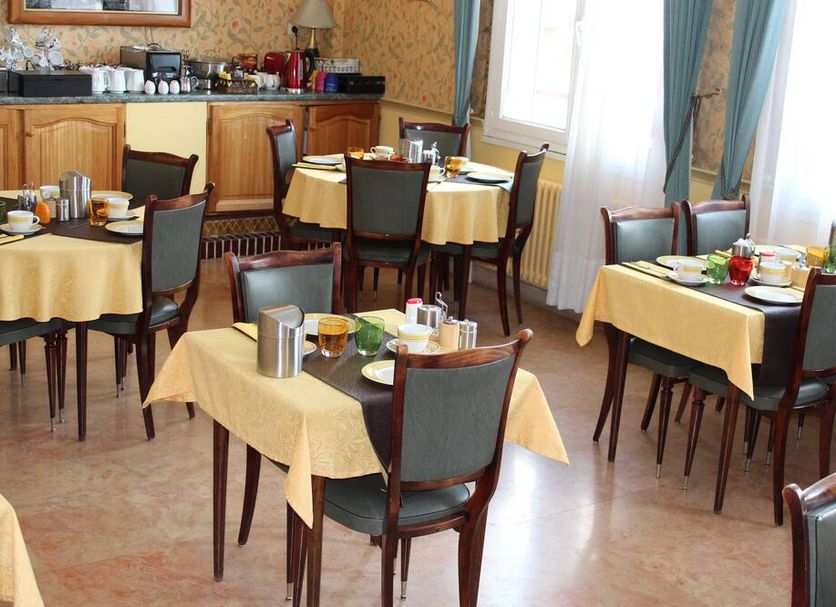 Hotel Bristol in Châlons-en-Champagne breakfast room with set dining tables and chairs